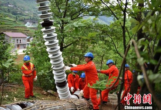 圖為電力工人首次在特高壓復(fù)奉線重慶段開展整串絕緣子串更換工作。　周毅 攝